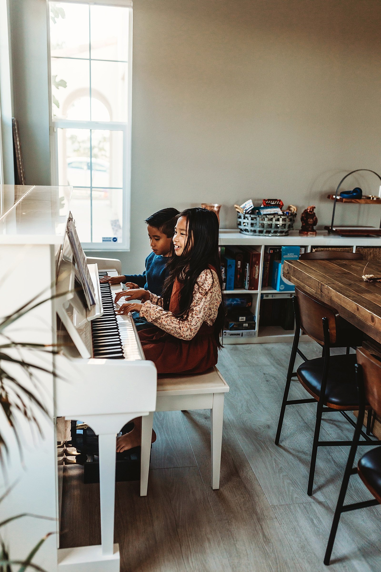  Two children playing a piano at their in-home family session in California  