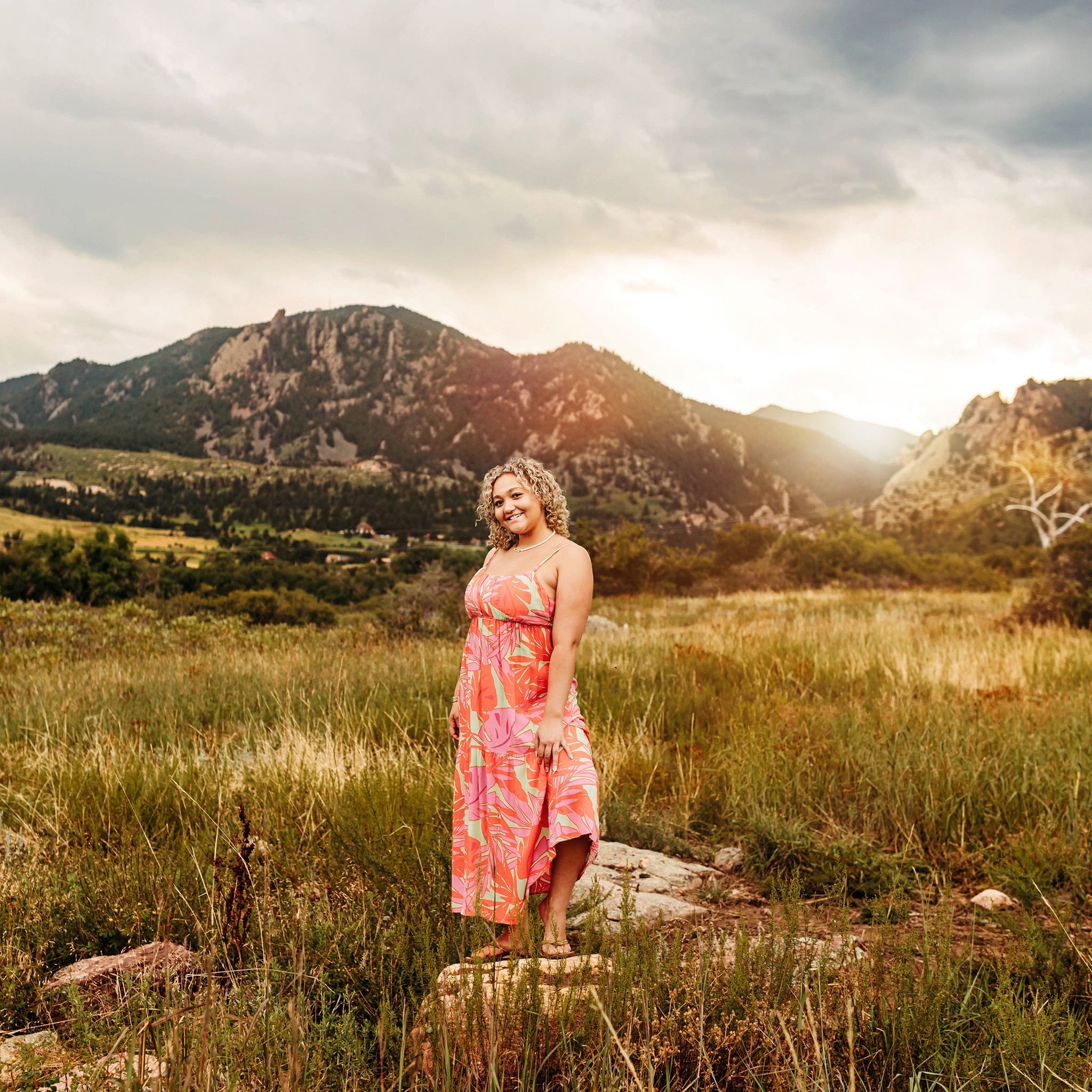 High school senior girl standing proudly in the Flat Irons mountains of Boulder.