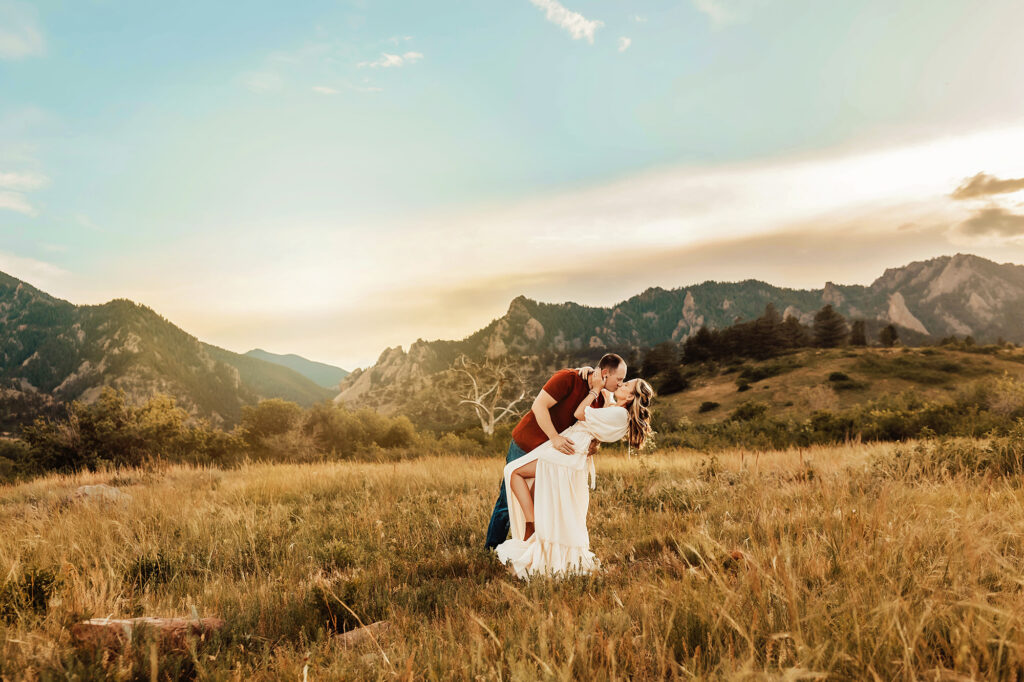 husband and wife running through the meadow in Boulder, Colorado. 