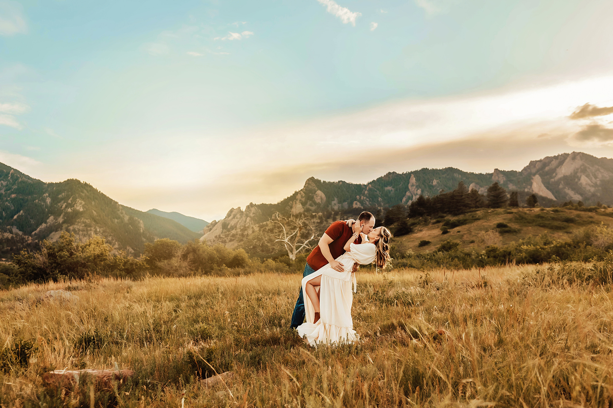 husband and wife running through the meadow in Boulder, Colorado.