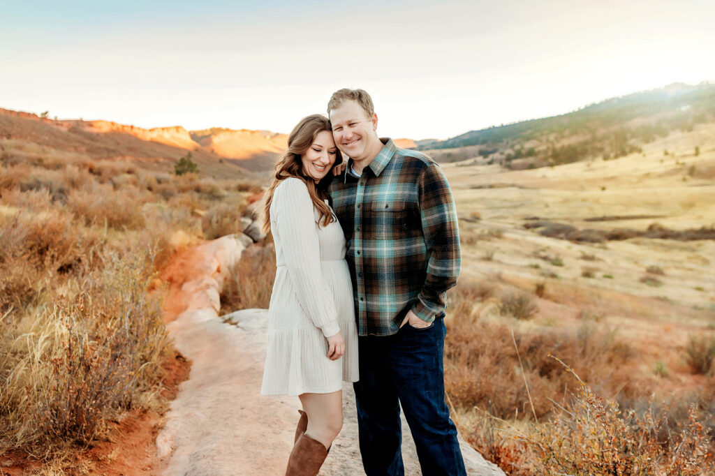 Husband and wife snuggling in Lory State Park. 