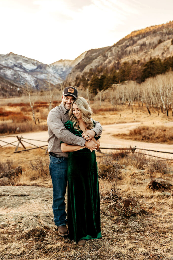 Husband and wife snuggling together in the Estes Park mountains. 